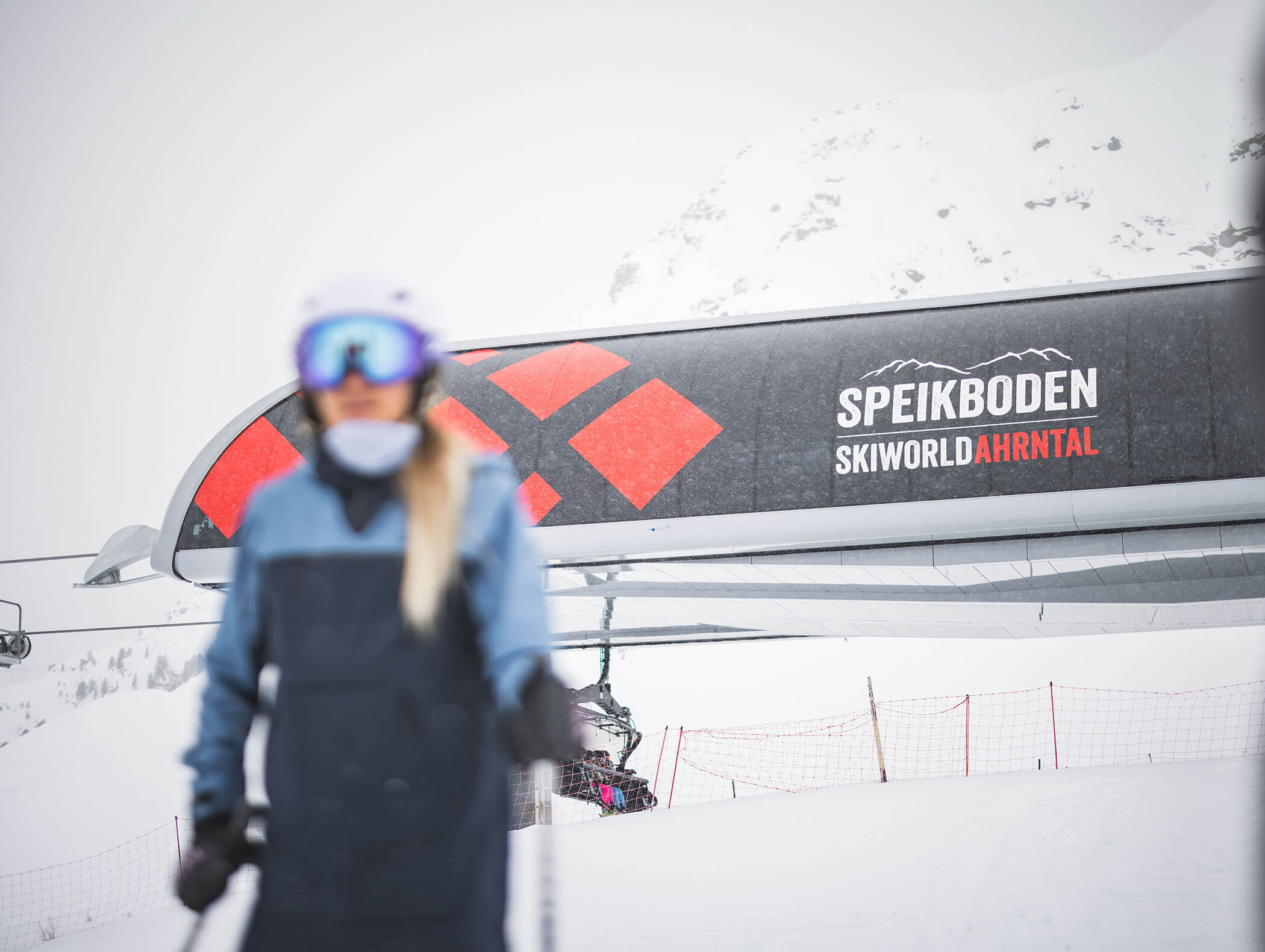 Ein Skifahrer steht vor einem Skilift mit dem Schild Speikboden Skiworld Ahrntal in verschneiten Bergen. - Maurlechnhof